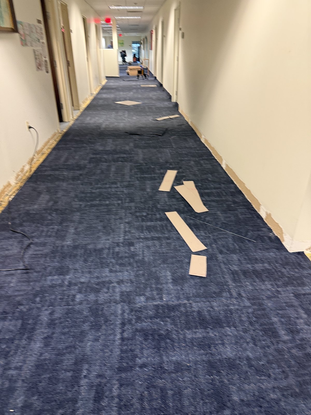 Nueva alfombra modular avanzando por el pasillo mientras nuestro equipo trabaja sección por sección con mínima interrupción.