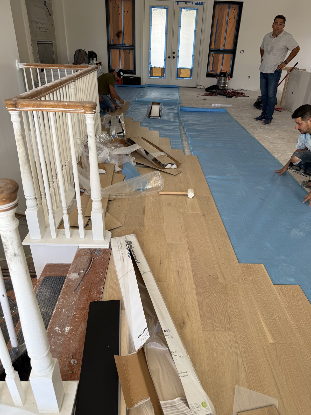 Nuestro equipo experto instalando un hermoso piso de madera resistente al agua sobre una base premium para una impresionante transformación del hogar.