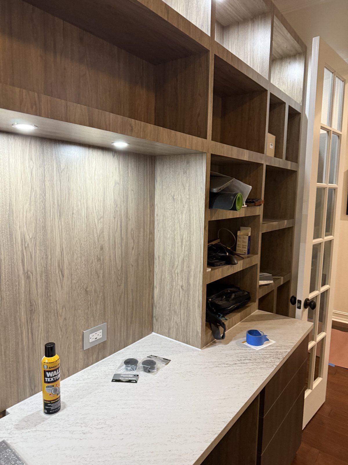 Trabajo de precisión en un mueble de oficina a la medida con encimera de cuarzo e iluminación bajo gabinete.