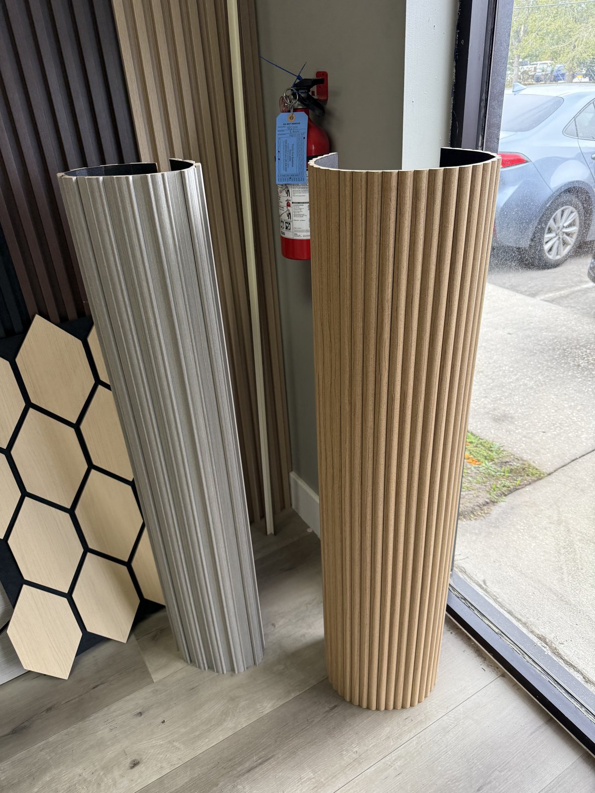 Paneles acanalados flexibles que envuelven columnas y curvas para un acabado arquitectónico moderno y uniforme.