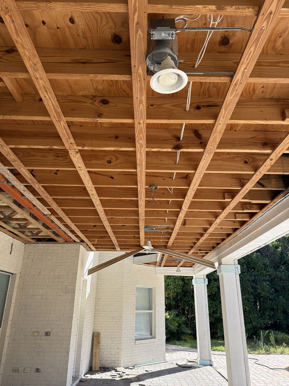 Trabajo estructural de techo en marcha en un patio cubierto, dejando a la vista una estructura sólida para una remodelación completa.